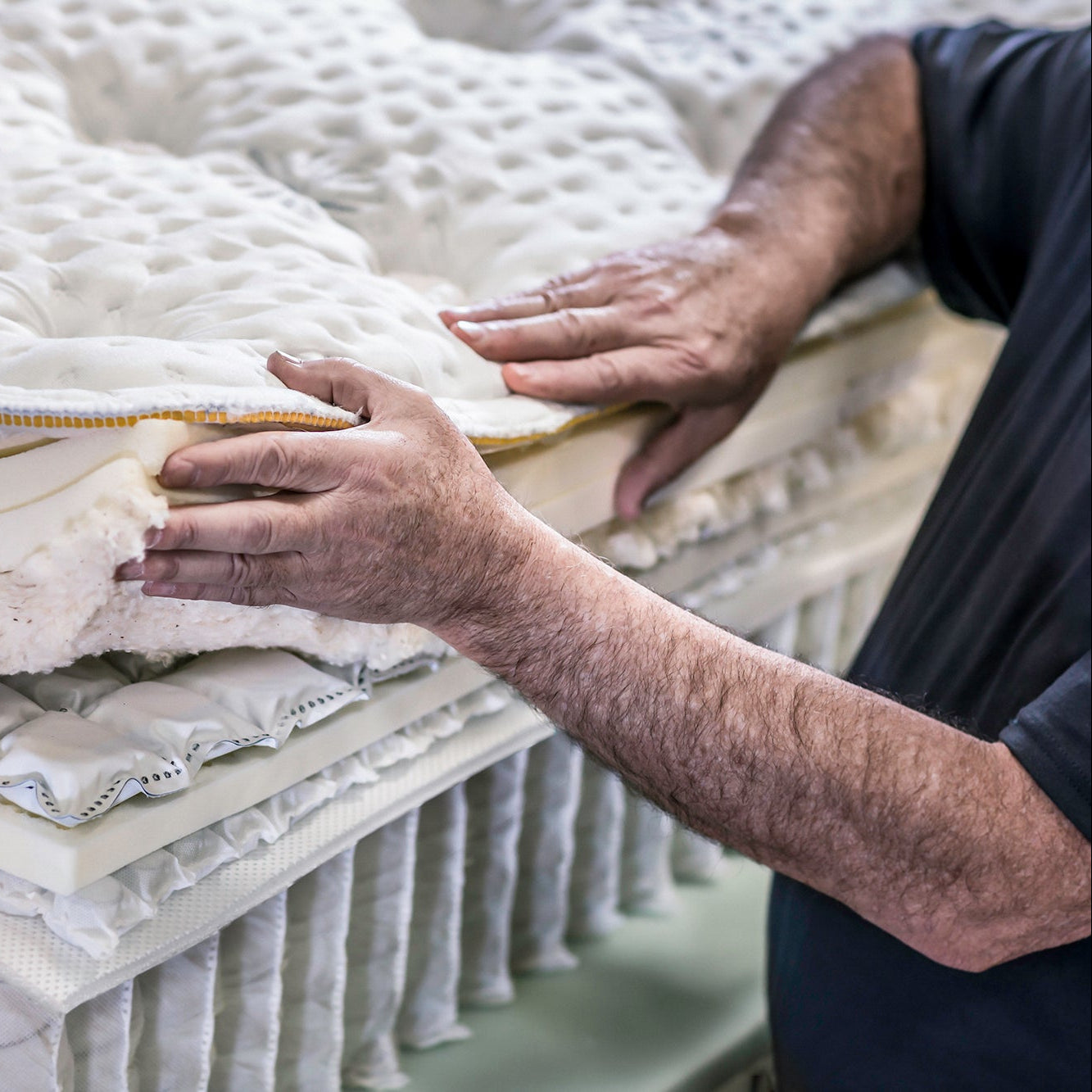 Person handling mattresses in a warehouse setting