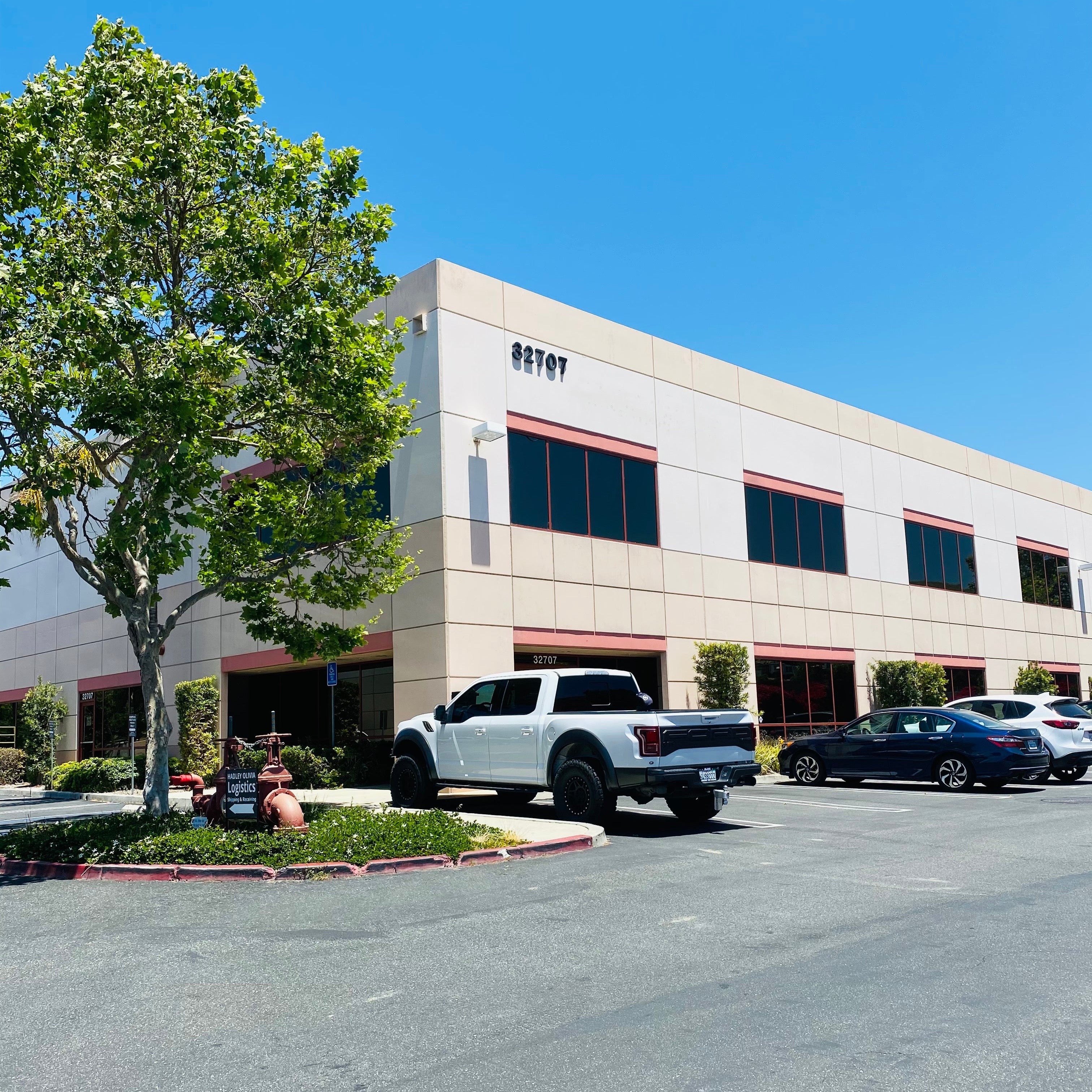 Commercial building with a white truck parked in front on a clear day