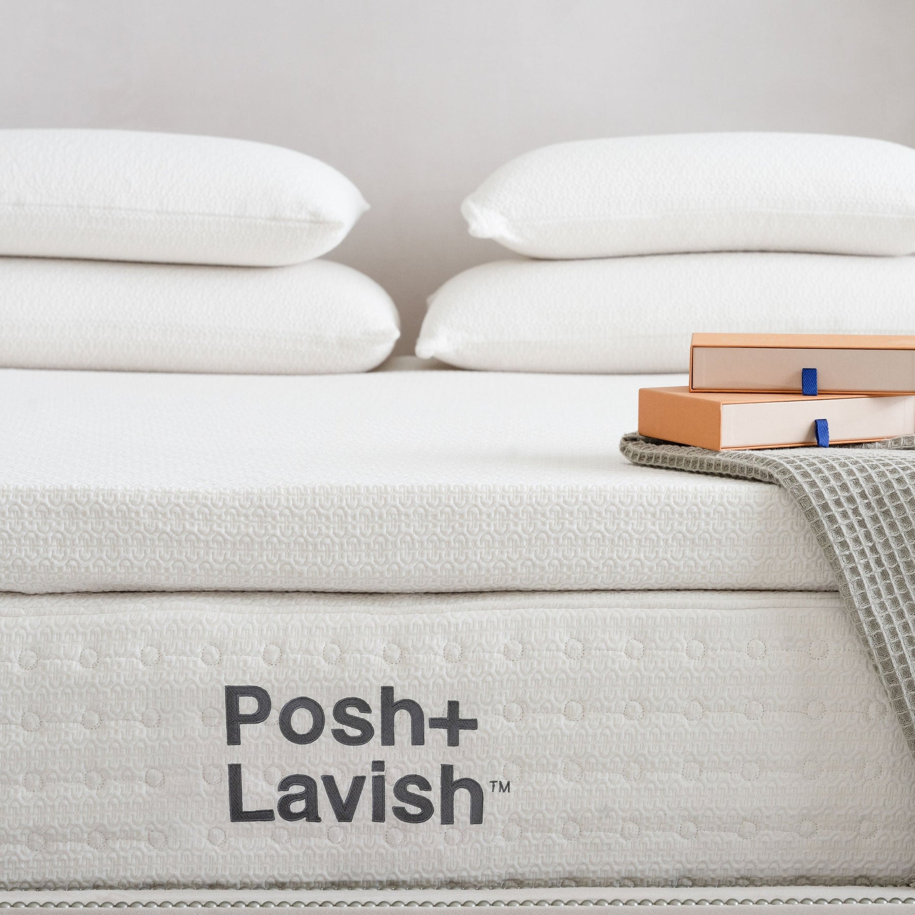 Posh+Lavish mattress with white pillows and a gray blanket